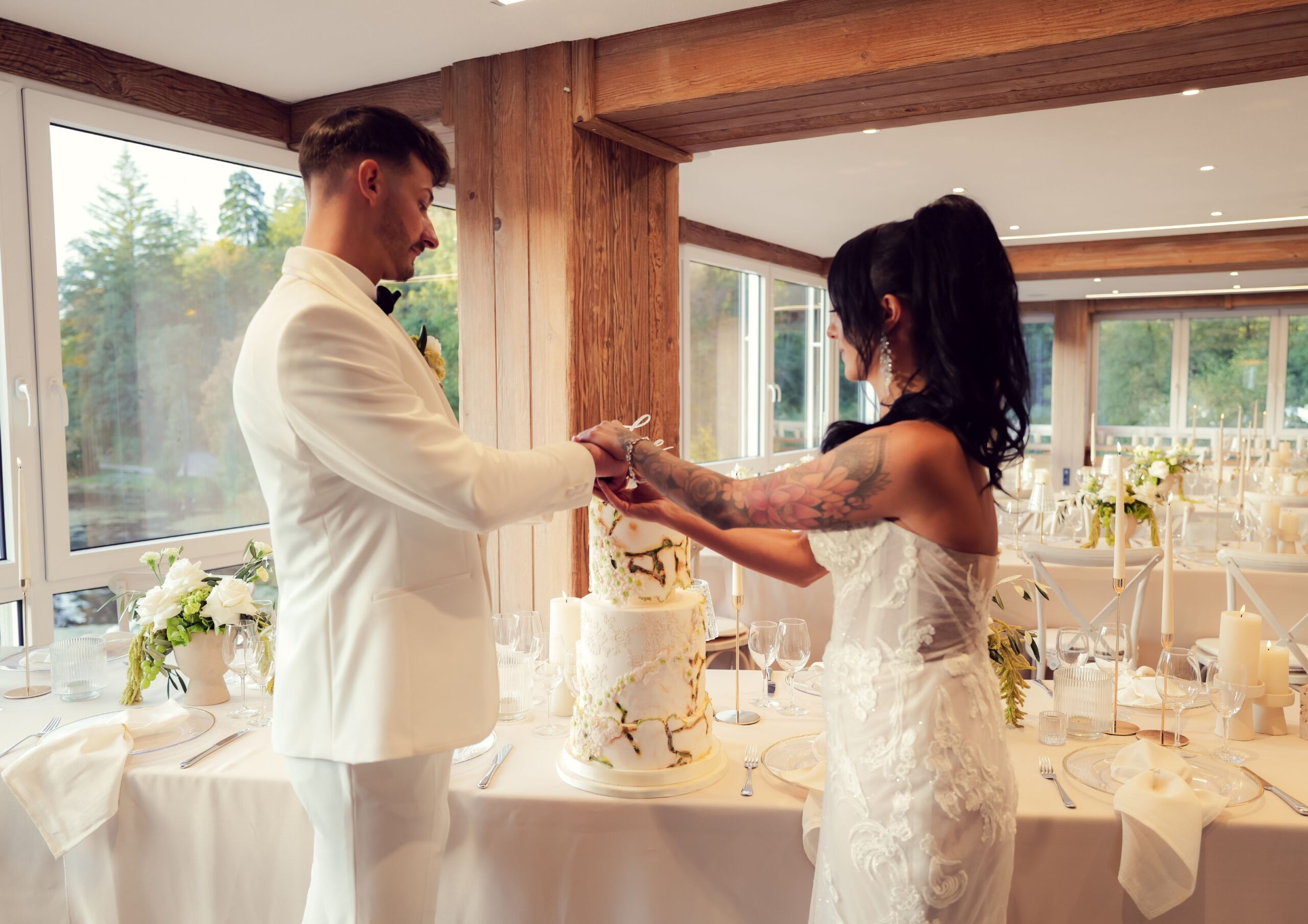 sh_festlichles_gedeck_fuer_hochzeitspaar_2 Ein festlich gedeckter Tisch für ein Hochzeitspaar mit goldenen Herzballons, Blumen, Gläsern und einer Tischdecke in Rot. Auf dem Tisch steht 'Mr & Mrs'.